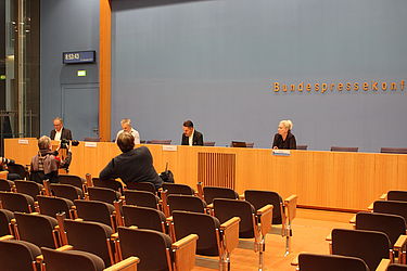 Gerhard Schick, Heribert Hirte und Fabio de Masi auf Podium der Bundespressekonferenz