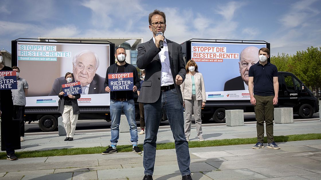Klaus Müller von der Verbraucherzentrale Bundesverband spricht bei Protestkundgebung vor Aktivsten, im Hintergrund das Kanzleramt